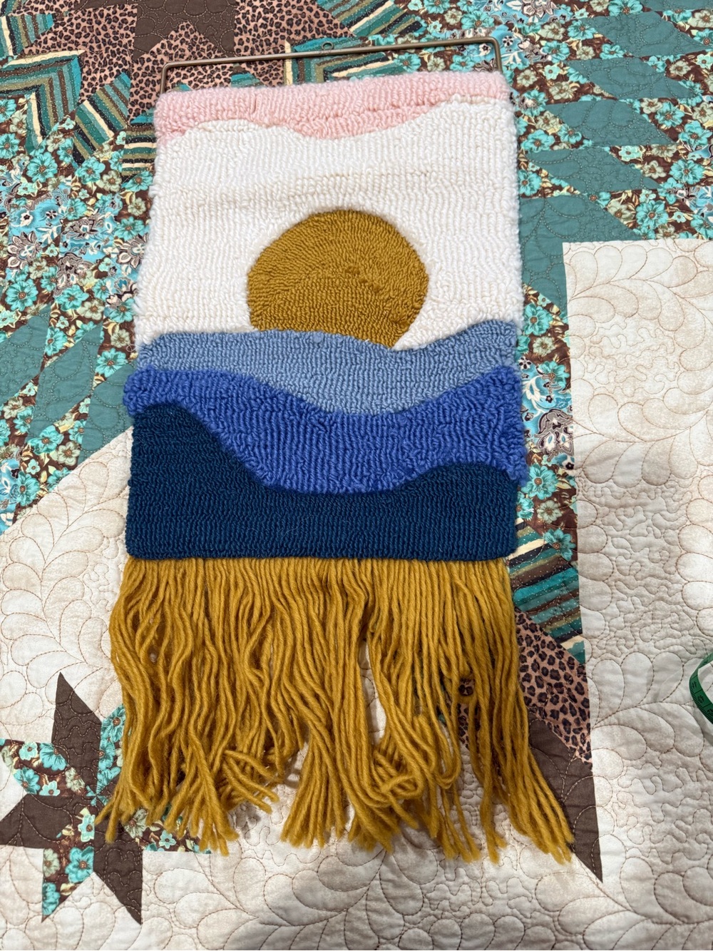 Urban Outfitters Sun Tufted Wall Hanging featuring a sun over blue ocean waves